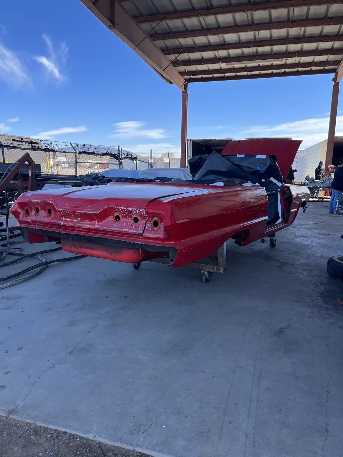 A 1963 Impala convertible in an old red respray, before dustless blasting.